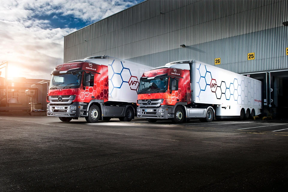 Two trucks parked at a loading depo