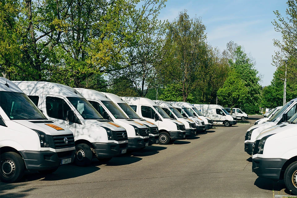 Parking lot filled with white delivery vans