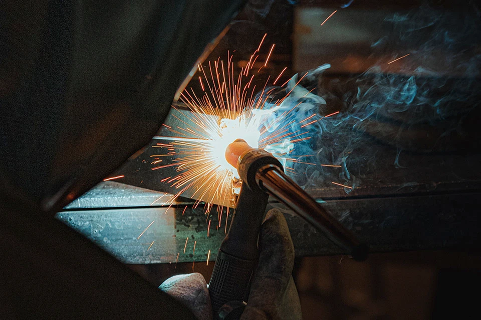 Close up of an engineer welding with sparks flying