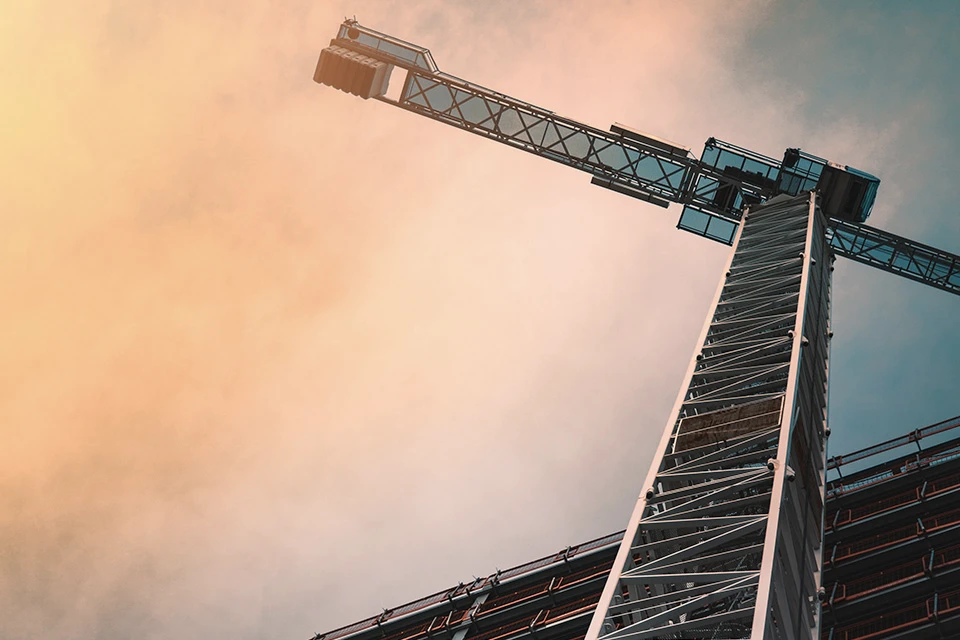 Looking up at construction crane above a construction site