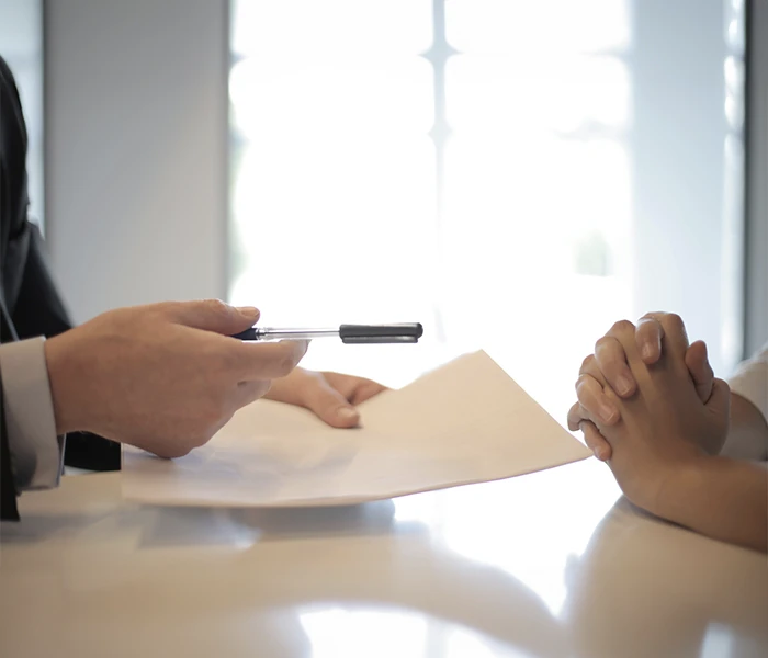 Man handing over a pen and paper to a lady